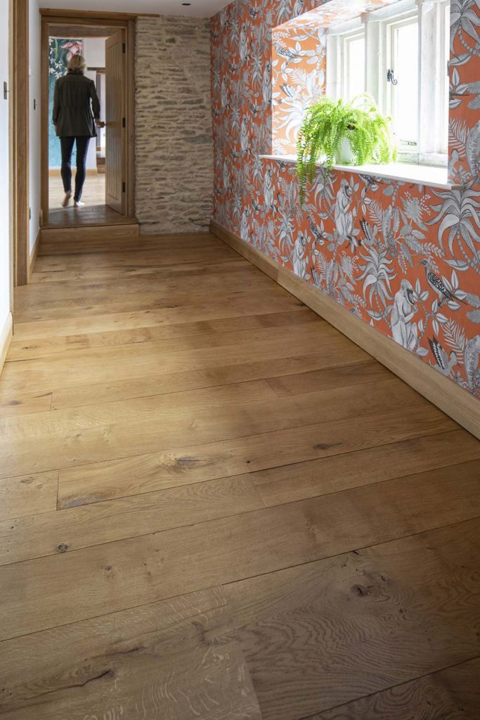 Wide solid oak floor boards with natural grain in a cottage hallway